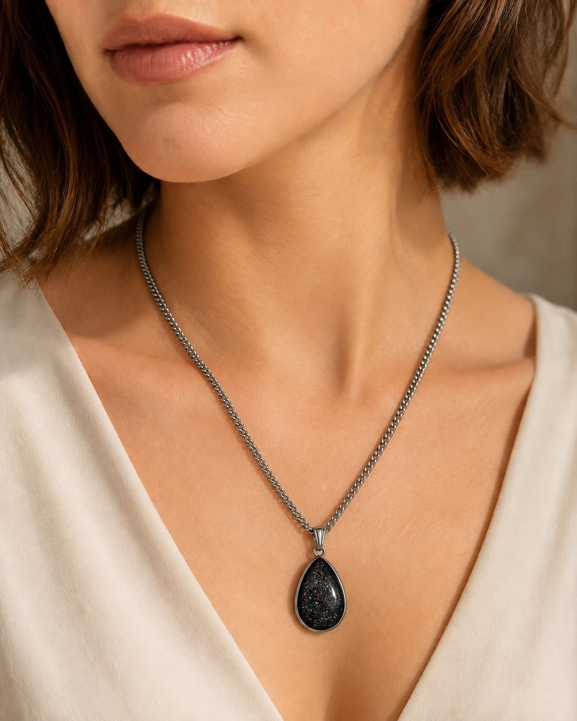 Black teardrop memorial pendant worn on a model