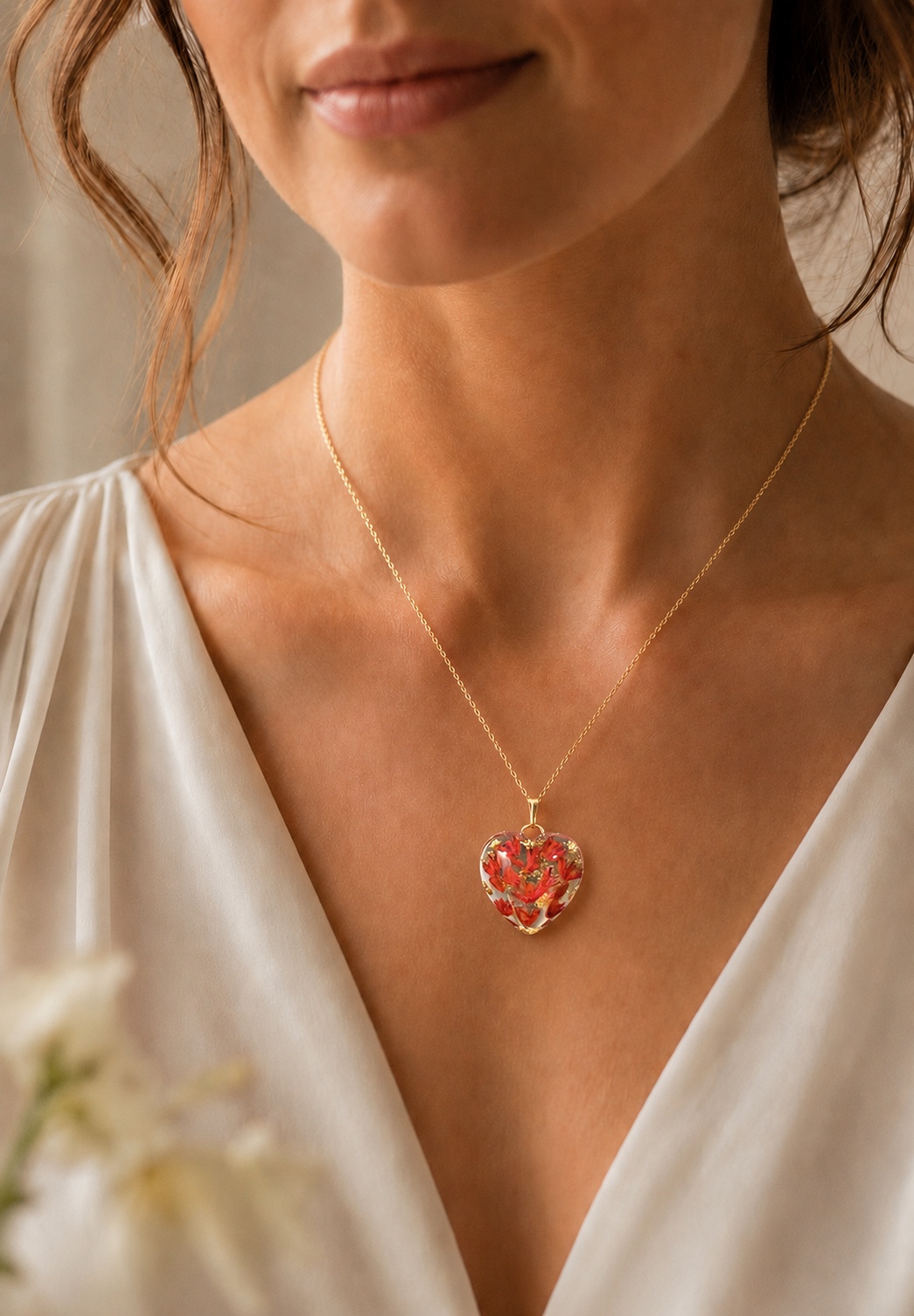 Kerry's red floral and gold memorial heart pendant worn on a model