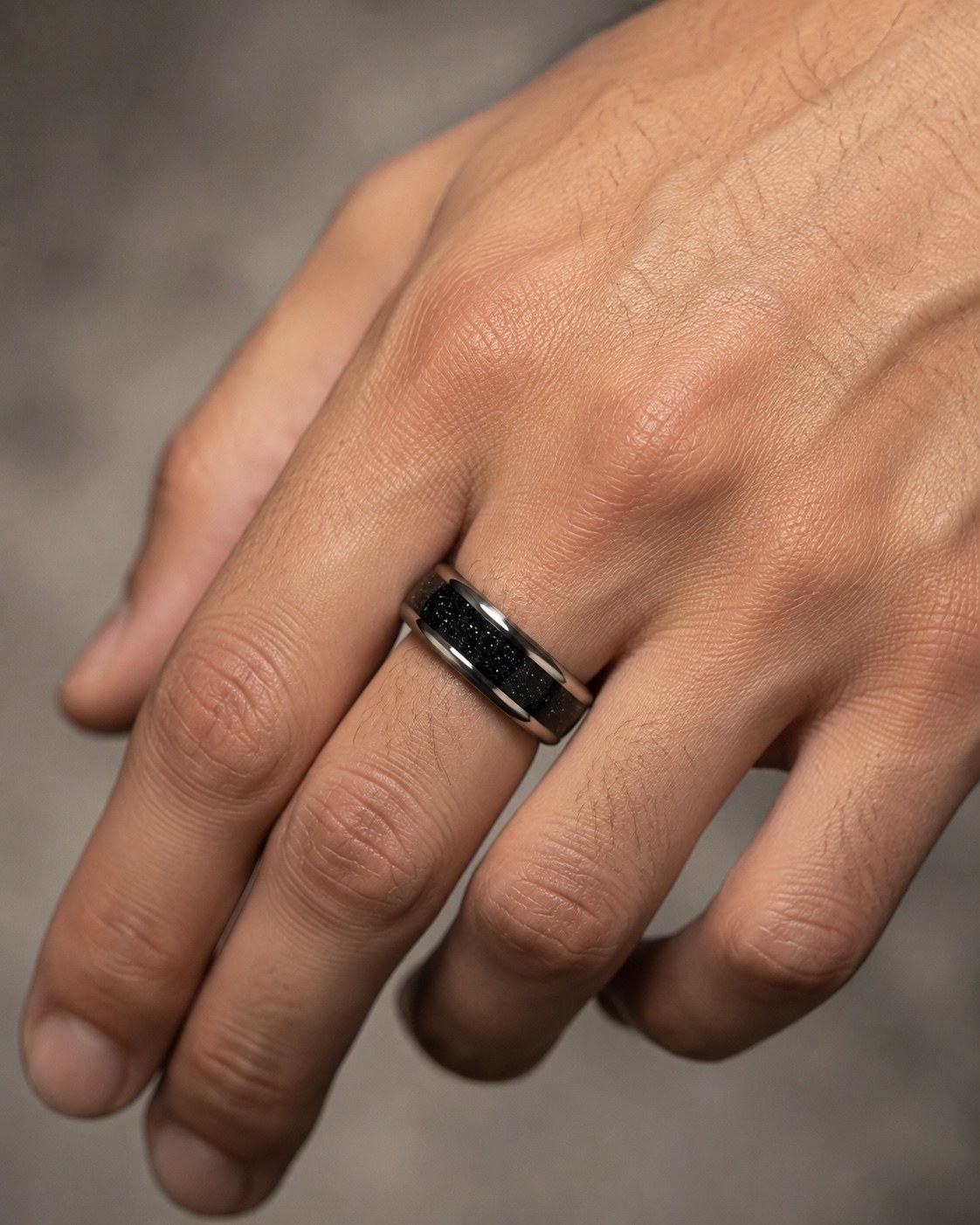 Black sparkle wide memorial ring worn on a male hand