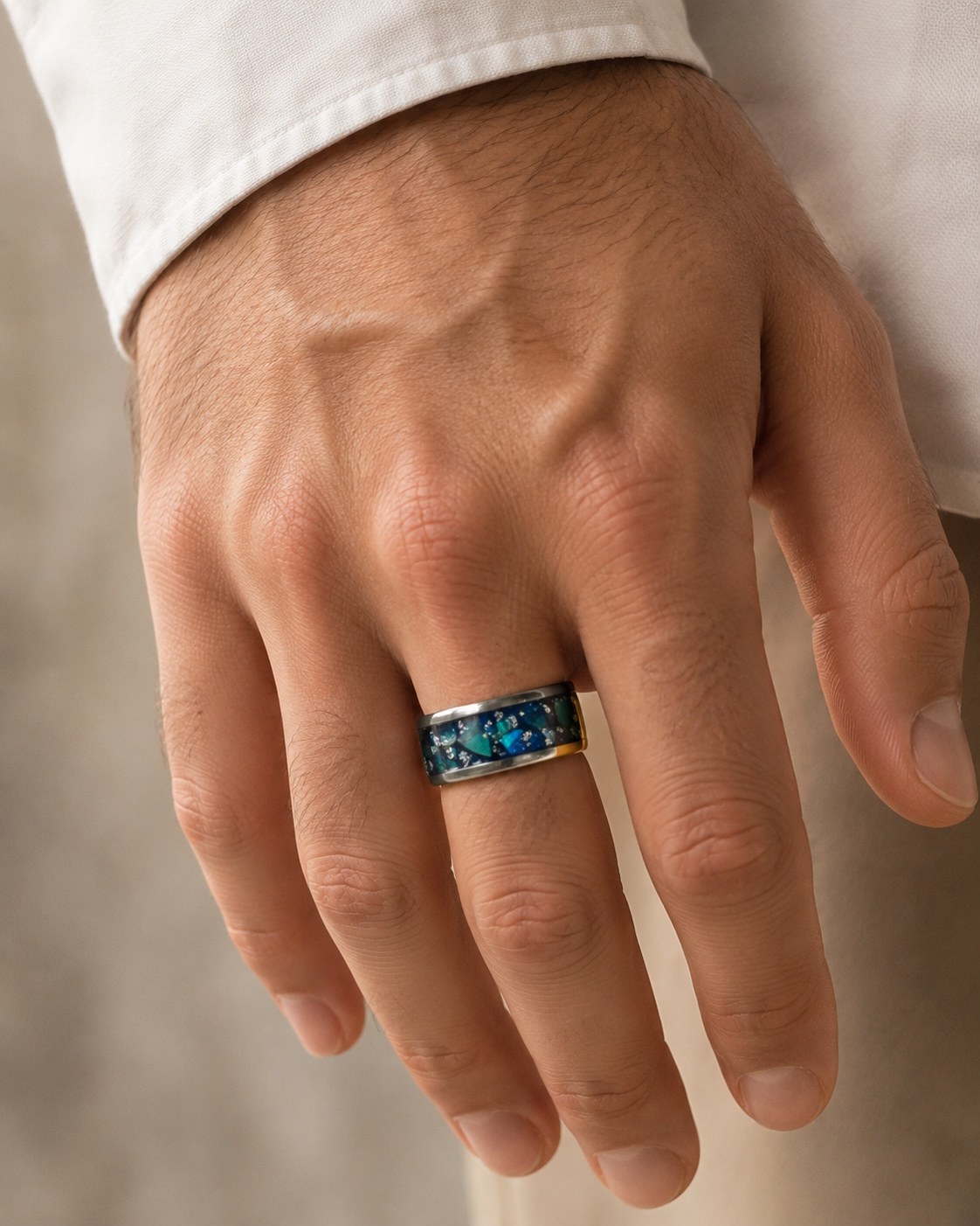 Blue green mosaic wide memorial ring worn on a male hand