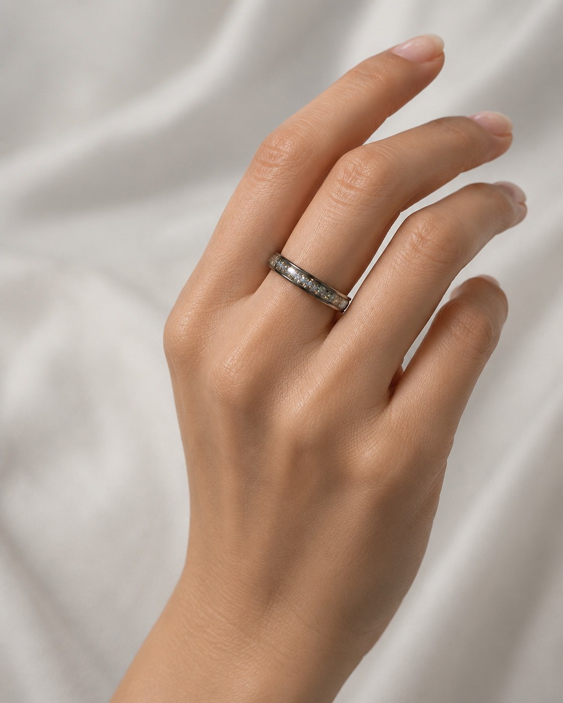 Silver sparkle memorial ring worn on a hand